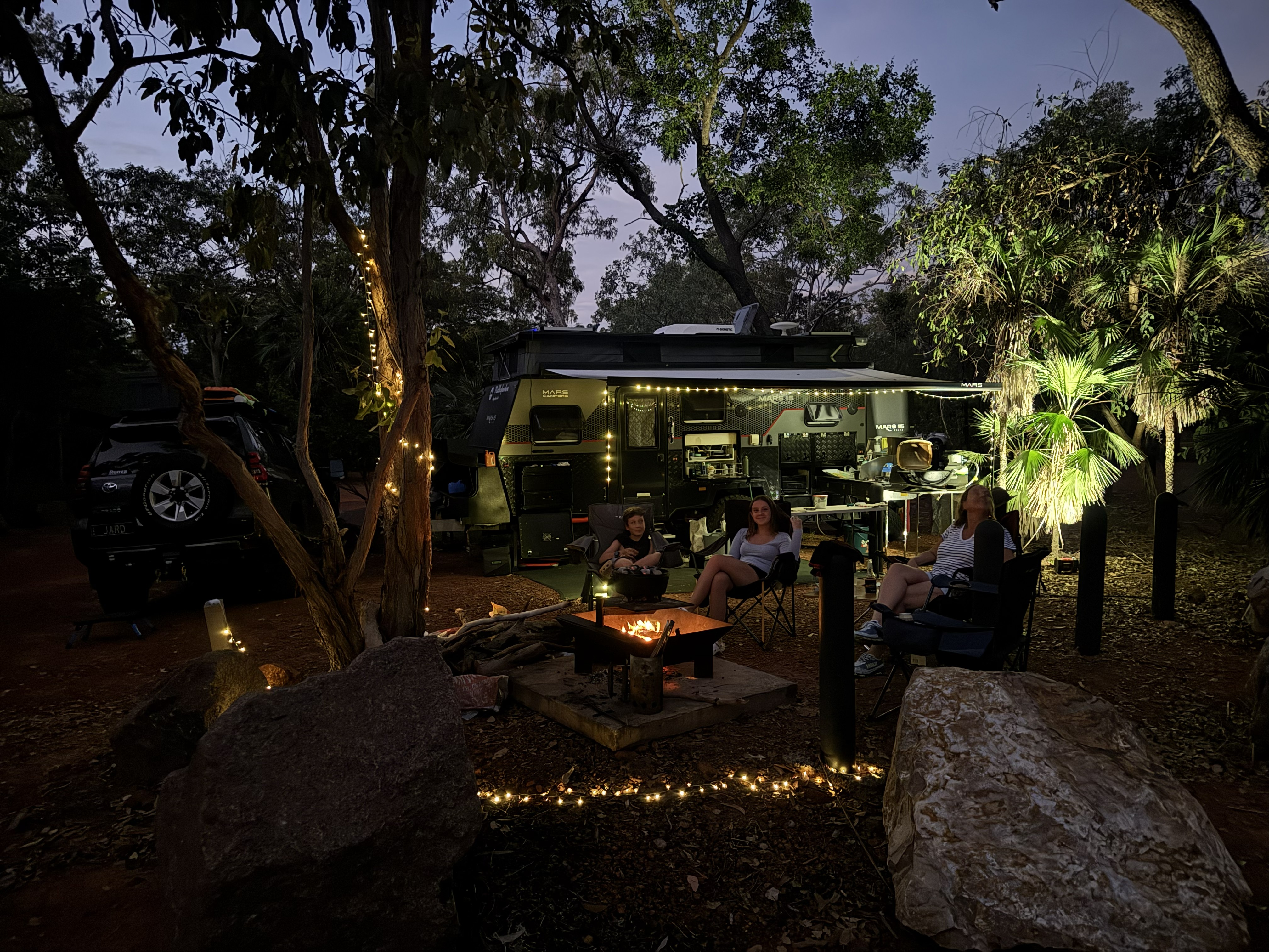 Camp set up at Litchfield — evening around the fire with the camper lit up